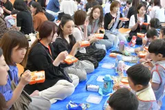 給食試食会で園児と一緒に昼食を食べる保護者たち