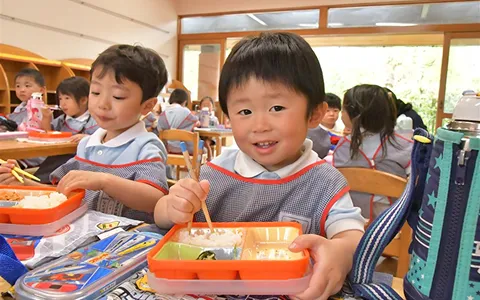 教室で弁当を食べる園児たち