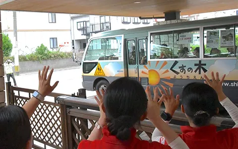 園バスを見送る園児たち
