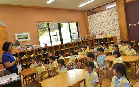 預かり保育で先生の読み聞かせを聞く園児たち