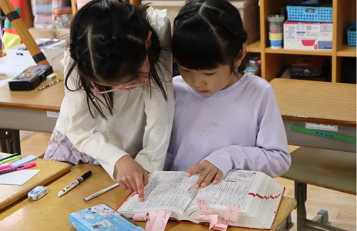 教室で一緒に辞書を引くくすの木学童塾の子供たち