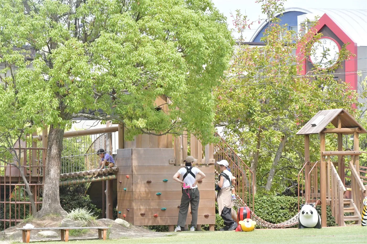 緑豊かな園庭で遊ぶ親子たち